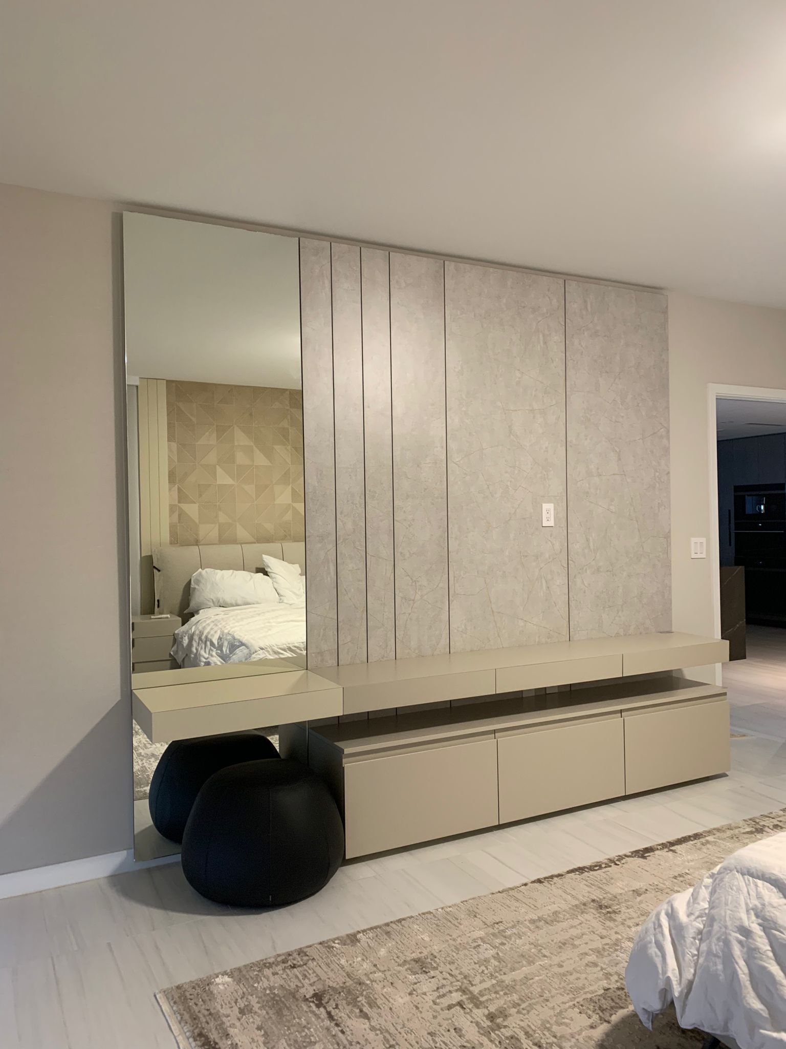 Modular bedroom wall with mirror, textured panels, and floating cabinets.
